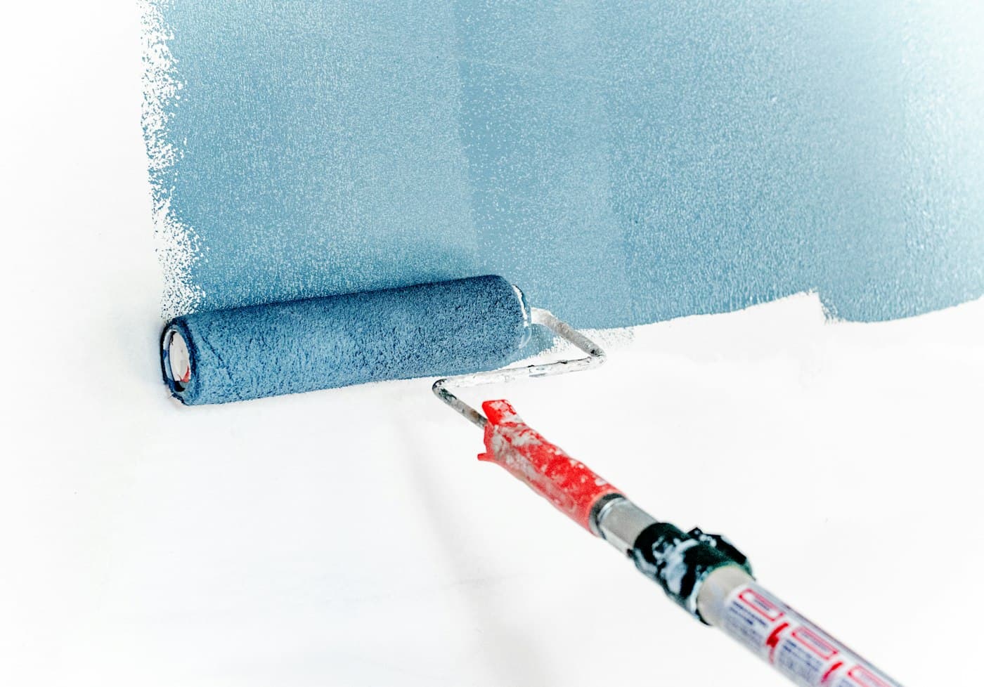 A paint roller painting a wall