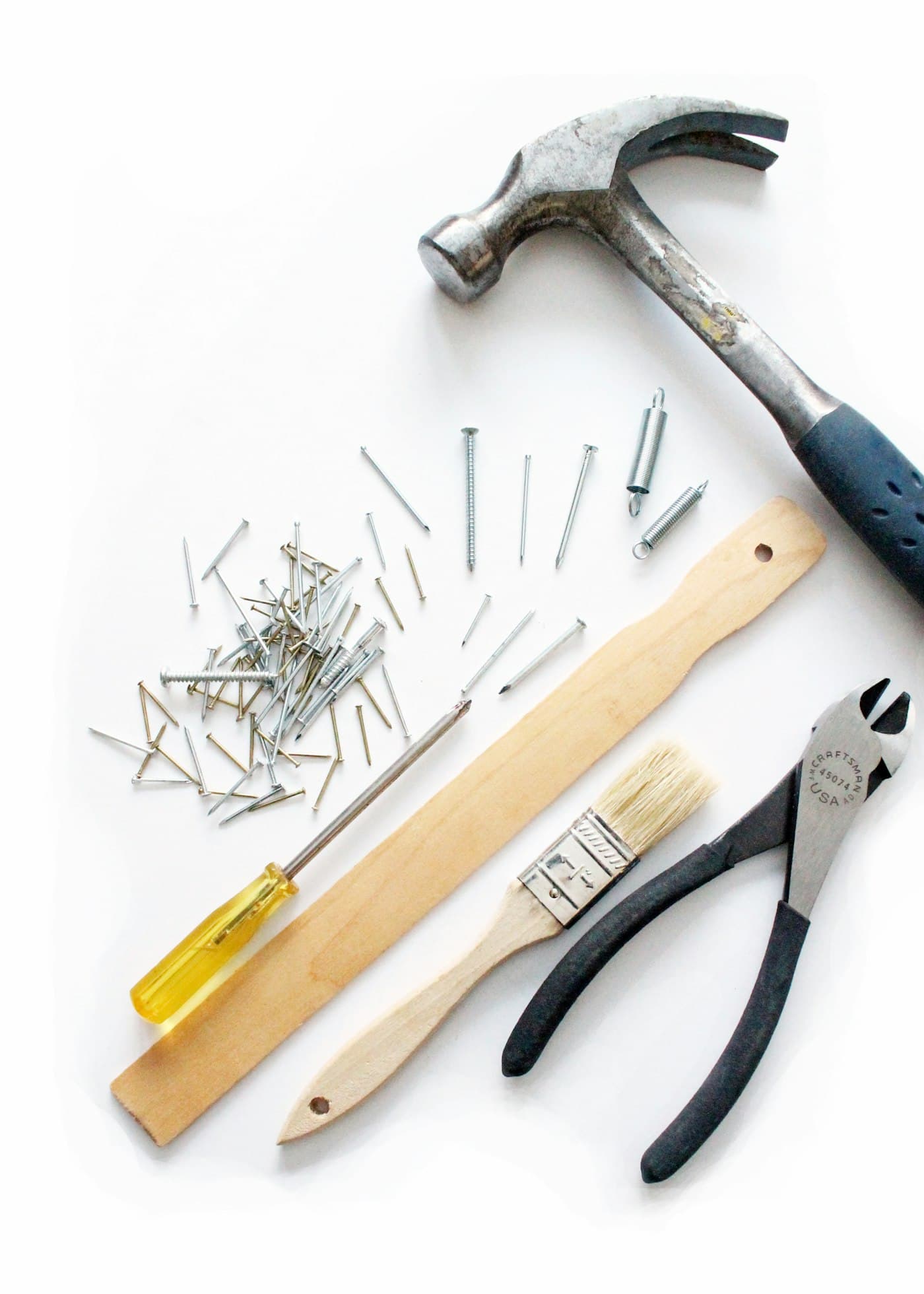 Hand tools laid out on a white surface